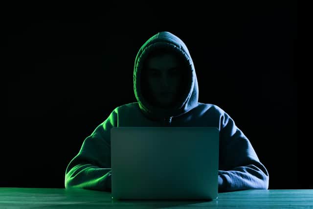 Silhouette of hacker with laptop at table on dark background. South Yorkshire Police have issued a warning over a new online scam.