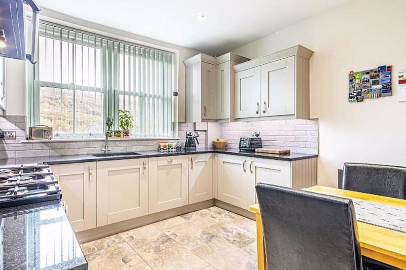 The kitchen diner has a range of shaker-style units with contrasting granite worktops and integrated appliances that include a dishwasher, fridge and freezer.