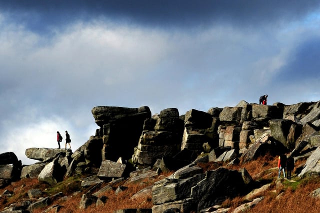 visitors clambering over the rock of  Stanage edge, Derbyshire  in 2011