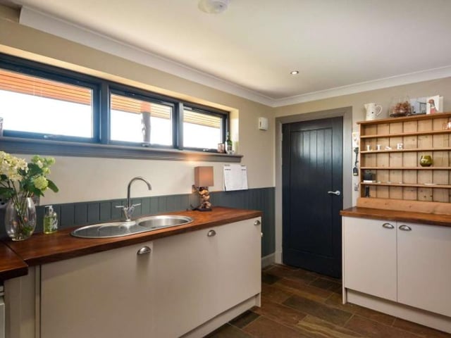 The utility room offers extra storage space, with wooden counter tops, cabinets, shelving and more. You can turn the room into whatever you like, including a pantry for cooking enthusiasts
