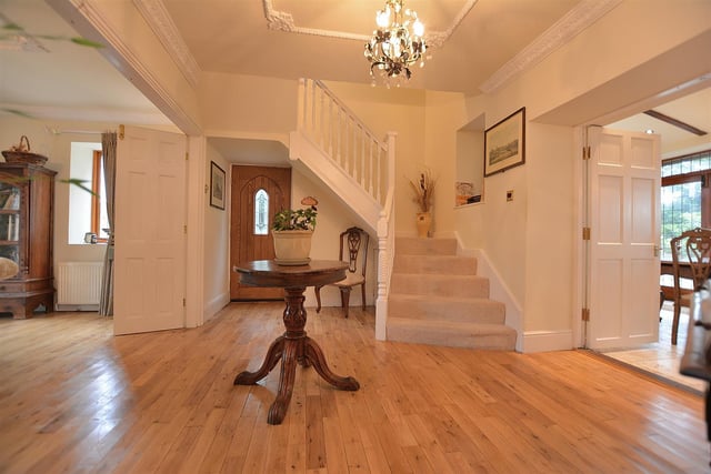 An inviting, large spacious central reception hall with oak flooring and stairs to the first floor landing.