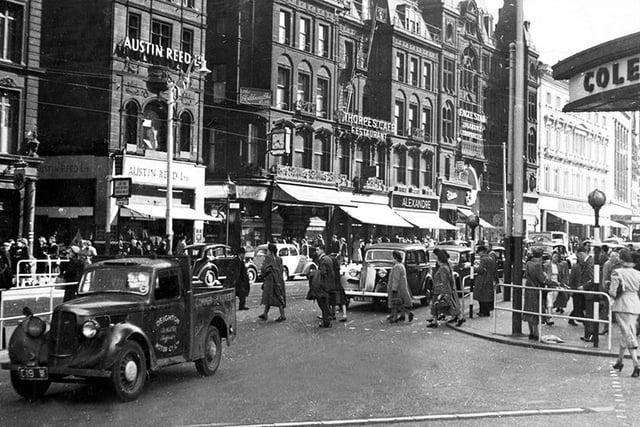 A view of a bustling Fargate circa 1930s with Cole Brothers department store on the right, and Austin Reed menswear, Thorpe's Cafe and Restaurant, and many other shops on the left