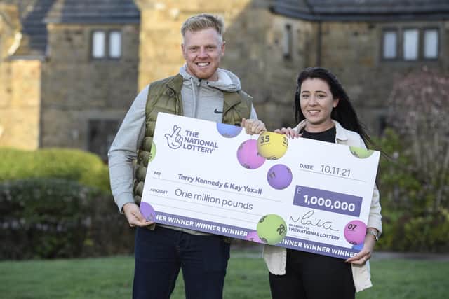 Terry Kennedy, 28, and Kay Yoxall, 25, celebrate winning £1 million on a Lotto Lucky Dip draw last month, in Tankersley, near Barnsley, northern England on December 8, 2021. Terry, who is a groundworker on building sites, discovered the win at work the day after purchasing his ticket. He matched five main numbers and the Bonus Ball in the Lotto draw on Wednesday 10 November.
