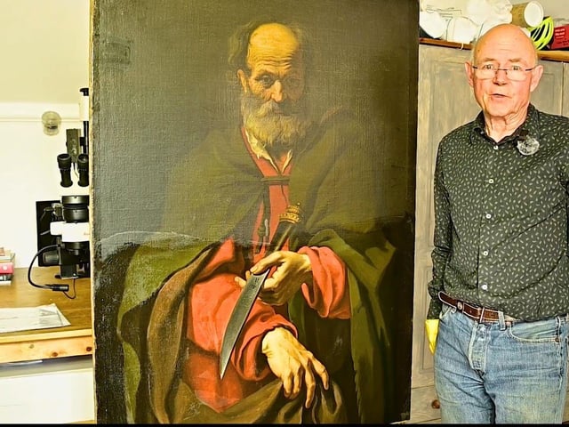 The painting of St Bartholomew, partially-cleaned, with art restorer Martin Wylde