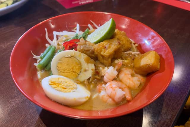 Curry Laksa - noodles in spicy coconut broth served with shredded chicken, prawns, boiled eggs, green beans, bean sprouts and tofu puffs.