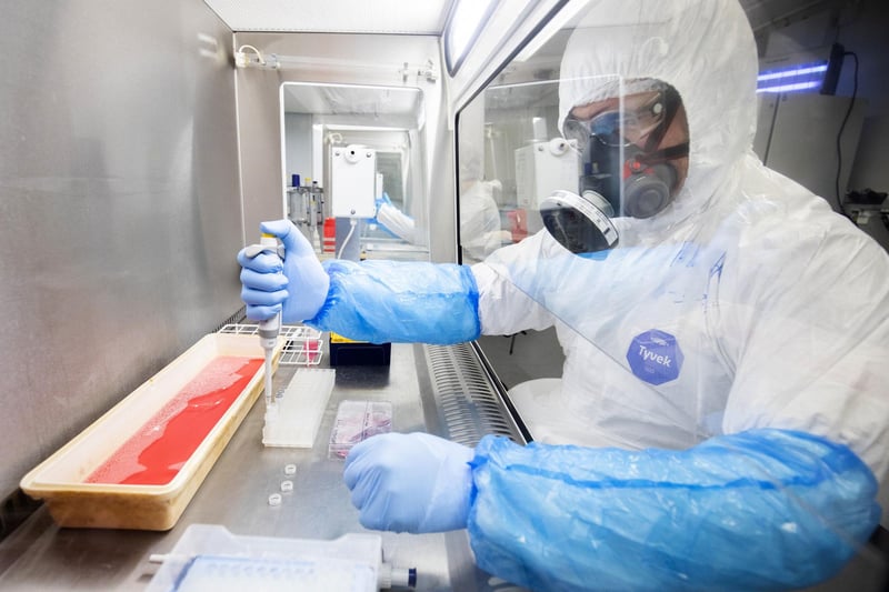 Dr Kieran Dee works in a Class II Microbiological Safety Cabinet with a sample of cultured cells that have been infected with SARS-CoV-2, the virus which causes COVID-19, to determine the genetic makeup of the virus