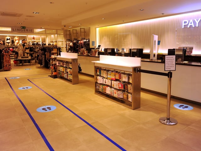 Socially distanced queuing and protective screens at the tills.