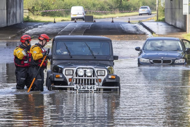Emergency services rescue drivers whose vehicles are stuck in flood water in Kirkliston, West Lothian, after heavy rain on October 4.