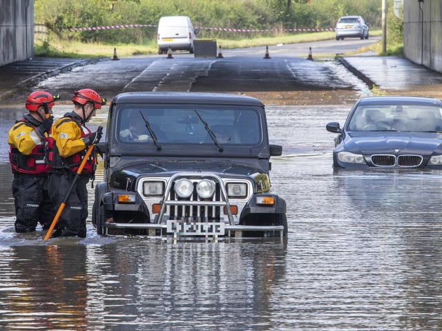 Emergency services rescue drivers whose vehicles are stuck in flood water in Kirkliston, West Lothian, after heavy rain on October 4.