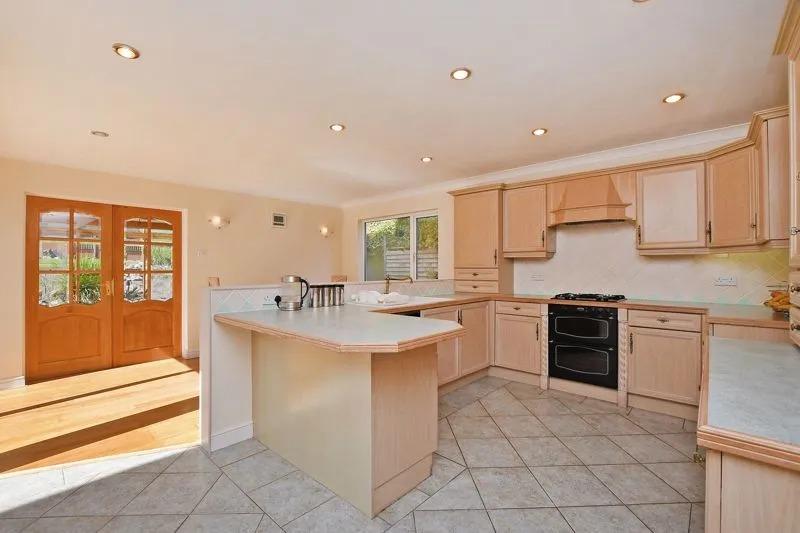 The kitchen has a range of base and wall units with integrated gas hob, extractor, double electric oven and dishwasher and opens into the dining area.