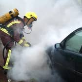 A motorist had to get out of their car after it caught light at traffic lights on Herries Road, Sheffield. File picture shows a firefighter dealing with a previous car blaze