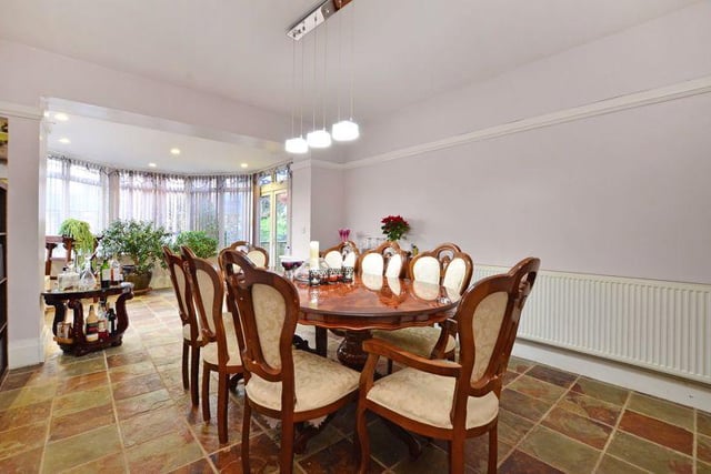 The open plan dining room/conservatory has tiled flooring and side-facing French doors that open into the garden.