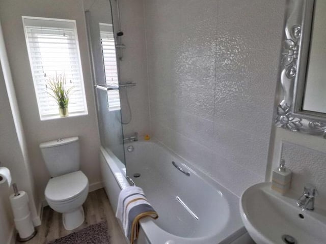 A three-piece white suite, comprising bath, wash hand basin and low-flush WC, makes up the family bathroom on the first floor of the Kernel Way house. Again, the wet areas are tiled, while the wood-effect floor is cushioned.