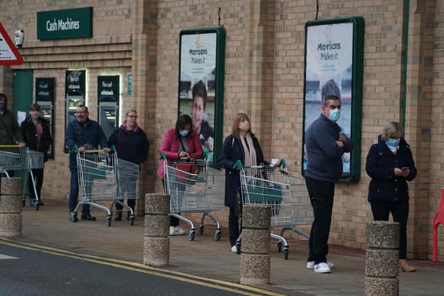 People queue outside a Morrisons supermarket in Whitley Bay, Tyne and Wear. PA