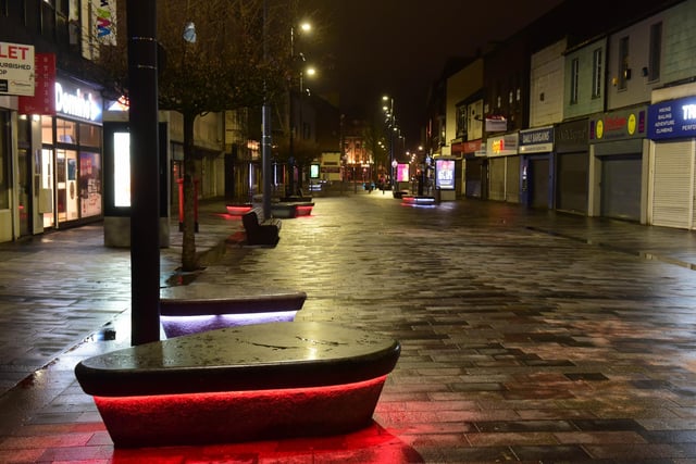 Seating lit red and white in High Street West