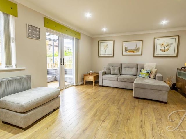 Opposite the kitchen is this living/dining room, which offers oodles of style and comfort. A feature fireplace and French doors leading outside are highlights, as is the laminate flooring.
