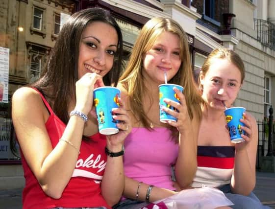 Three teens enjoying a cold drink on a summer day in 2003.