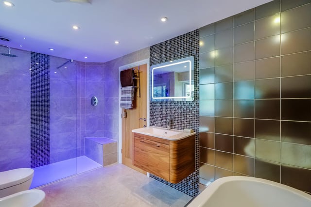 There are three bathrooms in total, including this stylish house bathroom complete with a freestanding bath, wash basin, toilet, bidet and walk in shower with a rain water effect head.