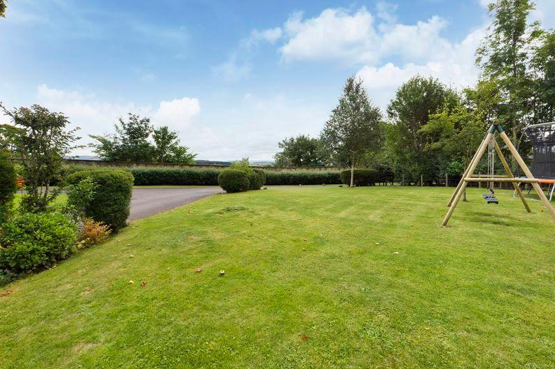 There is a large area of lawn to the front with a driveway for parking and double garage.