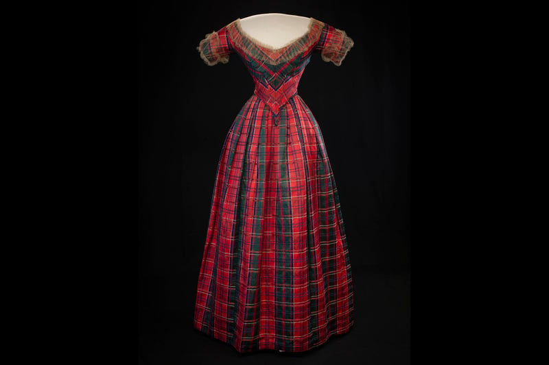 This tartan silk and satin dress was made in the 1840s to mark the visit of Queen Victoria and Prince Albert to Drummond Castle, Perthshire. It was worn to a lavish celebratory ball by Lady Willoughby d'Eresby alongwith a Highland bonnet of blue velvet trimmed with eagle feathers.