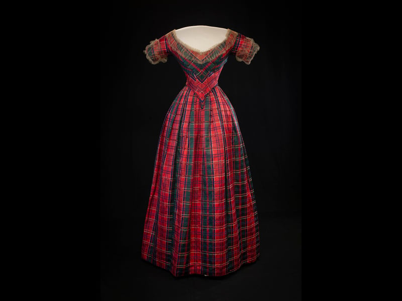 This tartan silk and satin dress was made in the 1840s to mark the visit of Queen Victoria and Prince Albert to Drummond Castle, Perthshire. It was worn to a lavish celebratory ball by Lady Willoughby d'Eresby alongwith a Highland bonnet of blue velvet trimmed with eagle feathers.