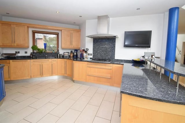Much of the ground floor is an open-plan family area, including this designer bespoke kitchen. It features a range of base and wall units in solid maple wood, with granite worktops, an inset stainless-steel sink and five-ring gas-burner with extractor hood.