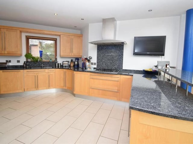 Much of the ground floor is an open-plan family area, including this designer bespoke kitchen. It features a range of base and wall units in solid maple wood, with granite worktops, an inset stainless-steel sink and five-ring gas-burner with extractor hood.