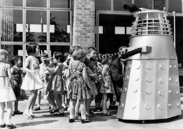 The children of the Maud Maxfield School, Sheffield, enjoy a visit from a Dalek, built by Thomas Ward and Sons Limited, in the playground of the school in 1965