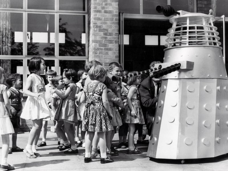 The children of the Maud Maxfield School, Sheffield, enjoy a visit from a Dalek, built by Thomas Ward and Sons Limited, in the playground of the school in 1965