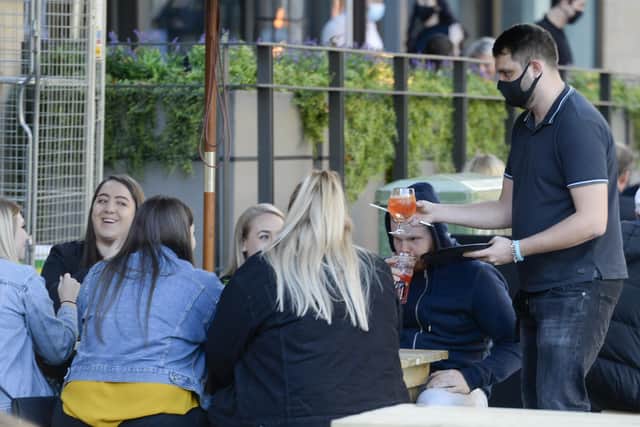 Drinkers are served at an outside table in Sheffield city centre on a night out.