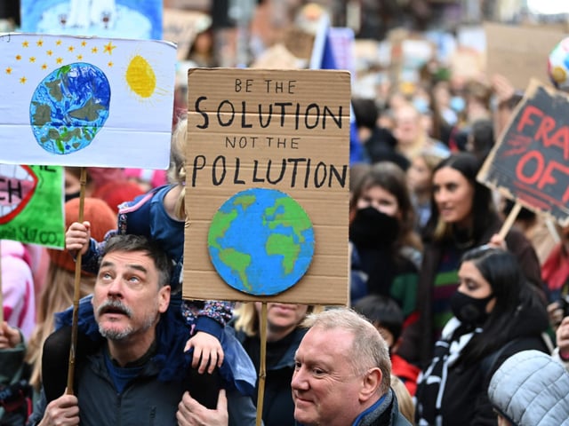 This placard even rhymes! It reads 'Be the solution, not the pollution'.