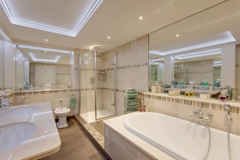 A sumptuous and generously proportioned en-suite bath/shower room. Suite in white by Imperial Bathrooms, which comprises a low-level WC, bidet, ‘his and hers’ wash hand basins with matching mixer taps and an inset panelled bath with additional hand shower facility.
