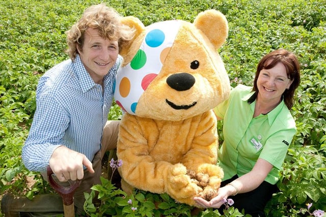Robin Kitching from E. Park and Sons and Lynn Bass from Asda join Pudsey in the field harvesting the potatoes in 2012