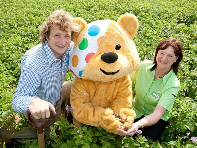 Robin Kitching from E. Park and Sons and Lynn Bass from Asda join Pudsey in the field harvesting the potatoes in 2012