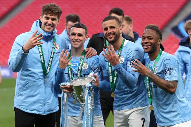 John Stones, Phil Foden, Kyle Walker and Raheem Sterling of Manchester City celebrate with the League Cup trophy (Photo by Clive Rose/Getty Images)