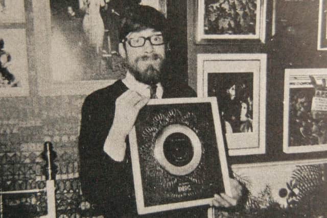 Dave Godin holding a silver disc for the Supremes' Baby Love in hisTamla Motown Appreciation Society office.