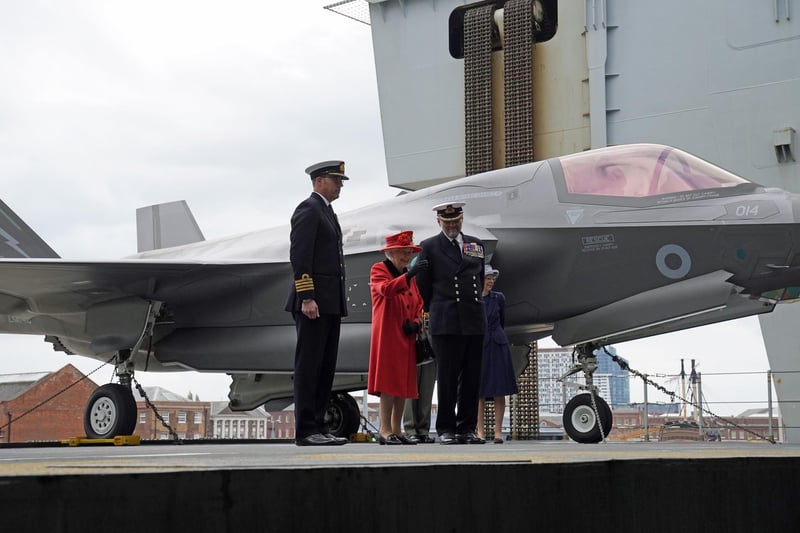 Captain Angus Essenhigh (left), Queen Elizabeth II (centre), and Commodore Steve Moorhouse, during a visit to HMS Queen Elizabeth at HM Naval Base, Portsmouth, ahead of the ship's maiden deployment. The visit comes as HMS Queen Elizabeth prepares to lead the UK Carrier Strike Group on a 28-week operational deployment travelling over 26,000 nautical miles from the Mediterranean to the Philippine Sea. Picture: Steve Parsons/PA Wire