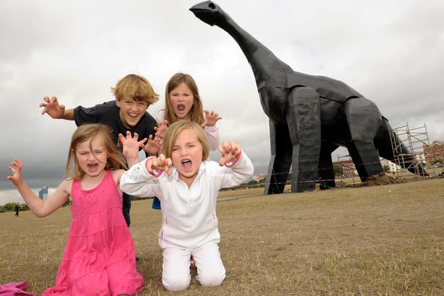 Thomas South (9) Isabella South (7,back right), Katie South(6,front left) and Heloise South (5, front right) enjoys a visit to the giant dinosaur statue on Southsea Common. 3rd July 2010. Picture:Steve Reid 102432-21