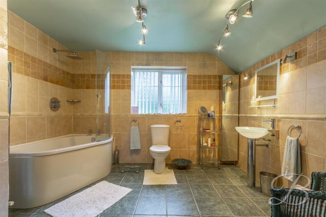 The bathroom has an enclosed shower, sink, wc, and tiled flooring.