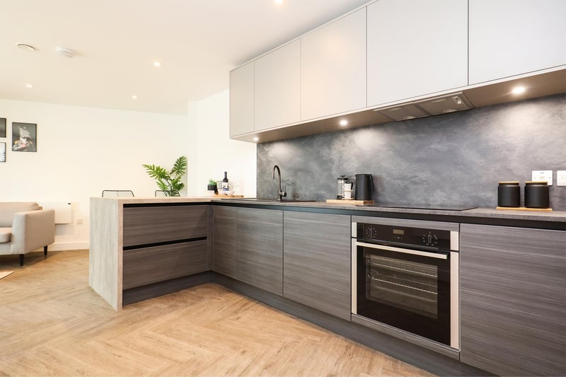 Top-end finishes in the matte, dark grey kitchens give a chic feel to the open-plan living space, with integrated appliances ranging from induction hobs to wine coolers.