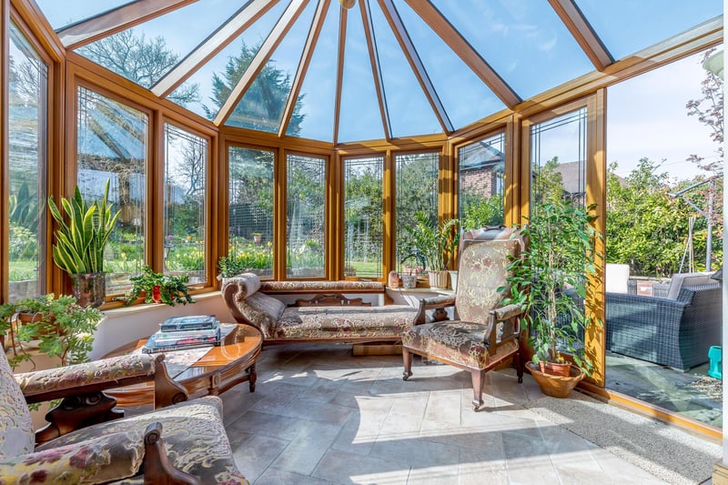 The conservatory offers a pleasant seating area, overlooking the garden with French doors out to both sides.