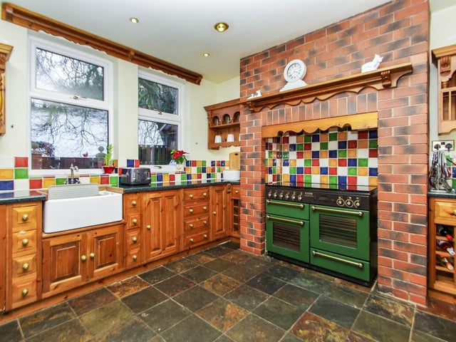 Fitted with a bespoke Farmhouse-style kitchen with solid wood base units, working surfaces, Belfast sink unit, space for a range cooker, complementary tiling to walls, slate tile floor, spotlights to ceiling, useful appliance space, two UPVC windows to rear.
