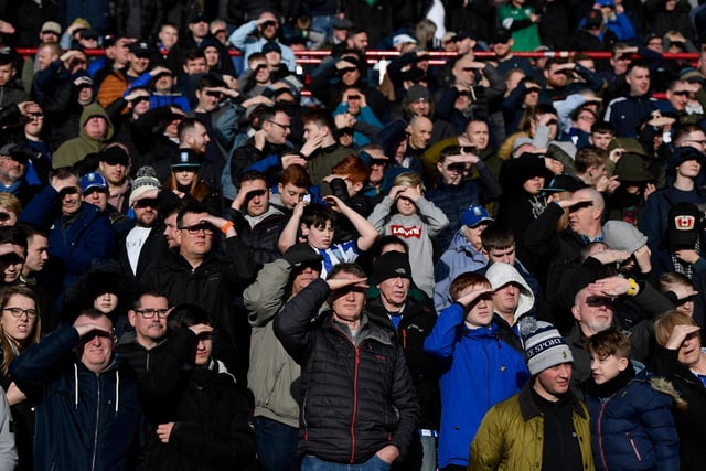Owls fans shade their eyes from the sun during the South Yorkshire derby against Barnsley at Oakwell in February 2020.