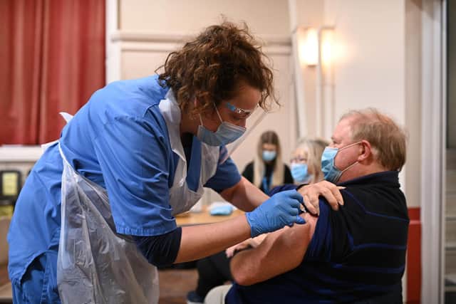 Nurse Sally Griffiths (L) administers an injection of AstraZeneca/Oxford Covid-19 vaccine to a patient at the vaccination centre set up at St Columba's church in Sheffield. (Photo by OLI SCARFF/AFP via Getty Images)