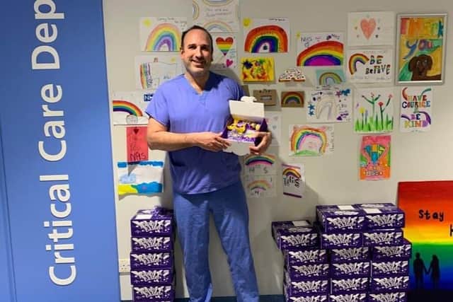 Joan Pons Laplana in front of the rainbow wall at Sheffield's Royal Hallamshire Hospital