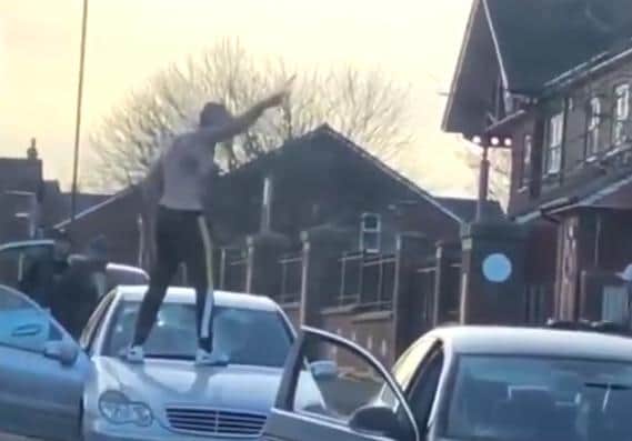 A man is seen brandishing what appears to be a knife during an armed fight in East Dene, Rotherham (still from video shared by @kwilliam111)