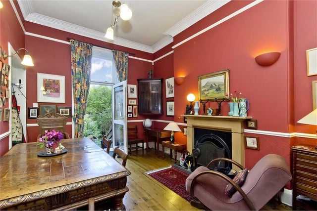 The dining room's rich-red decor complements the elegant features to be found throughout the house, and a French door leads to the garden beyond.
