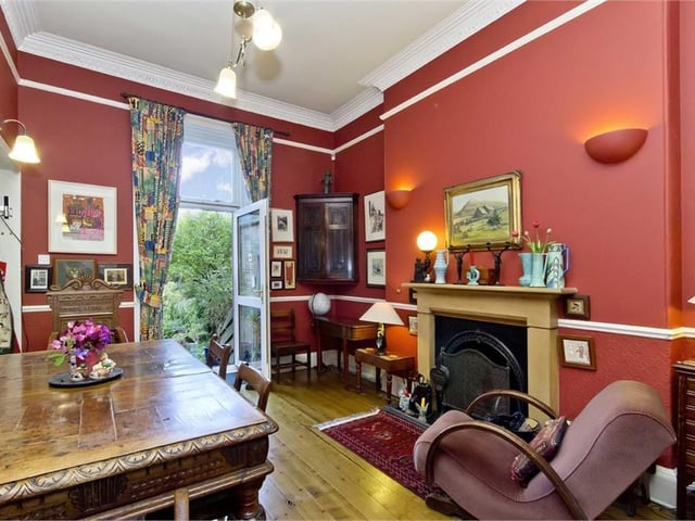 The dining room's rich-red decor complements the elegant features to be found throughout the house, and a French door leads to the garden beyond.