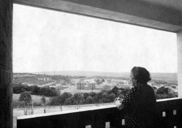 A woman gazes out over the city from her flat in a 13-storey block in Gleadless Valley, Sheffield, in 1961