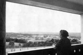 A woman gazes out over the city from her flat in a 13-storey block in Gleadless Valley, Sheffield, in 1961